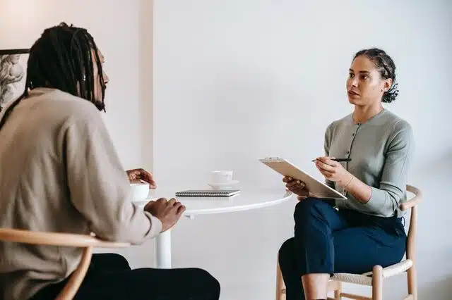 Ethnic female psychotherapist listening to black clients explanation