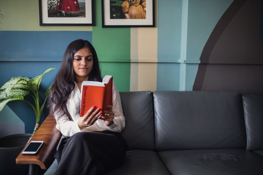 psychiatry-waiting-room woman reading Donald Judd Writings on the couch