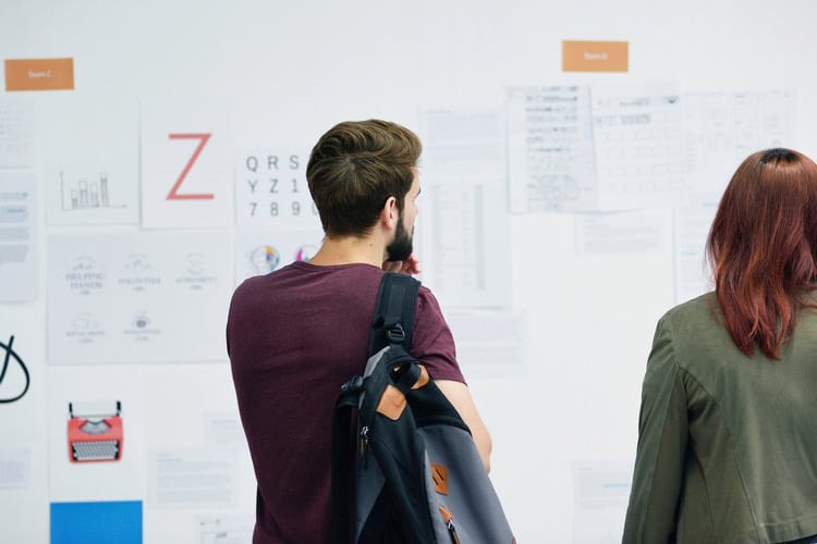 man and woman looking at notes on a whiteboard