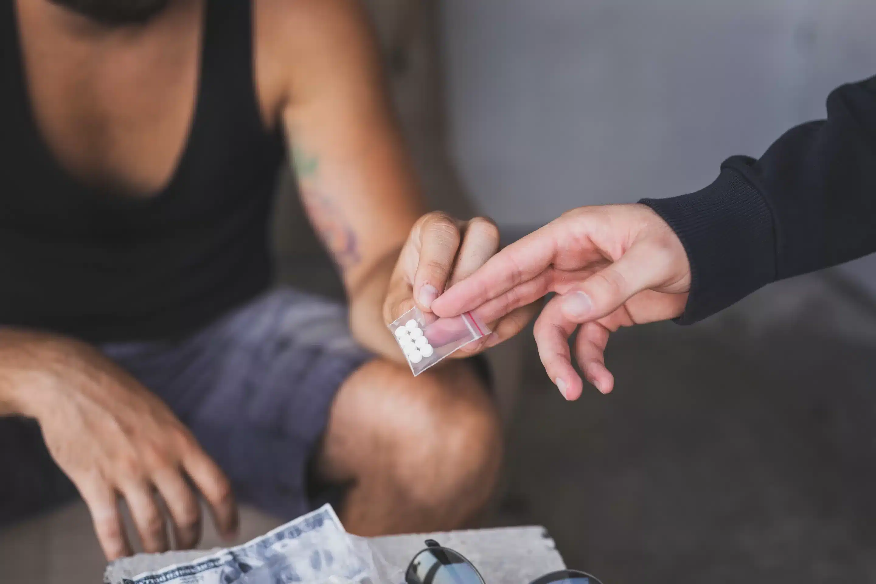 Drug dealer selling ecstasy pills to a drug addict
