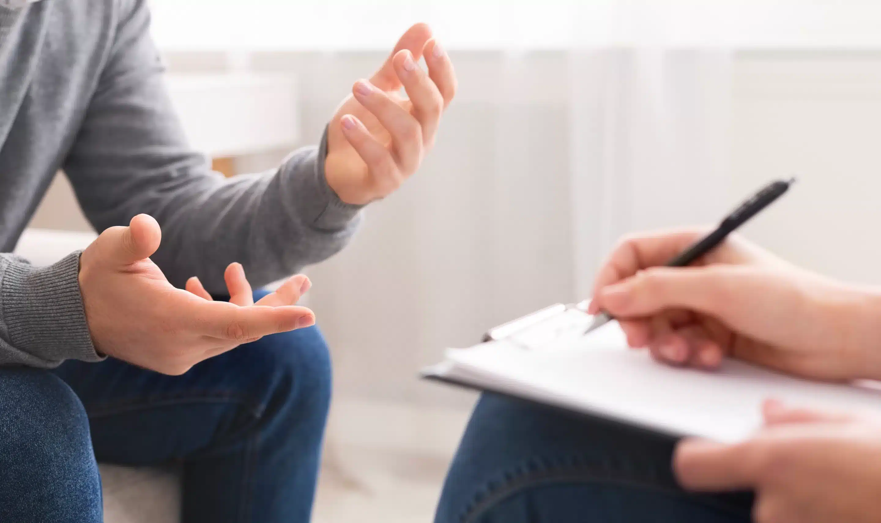 a person holding a pen and talking to another person