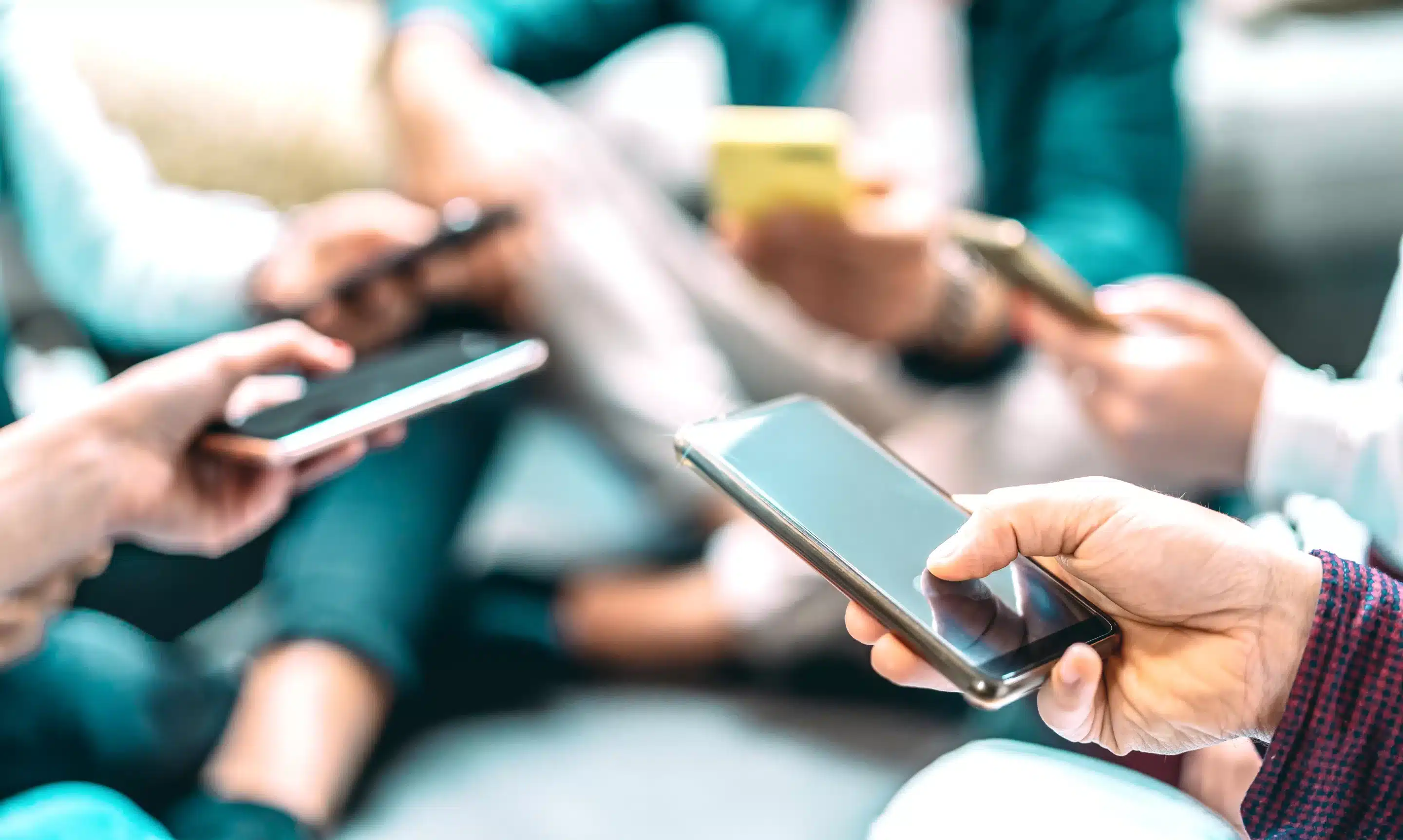 Close up of people using mobile smart phones -
