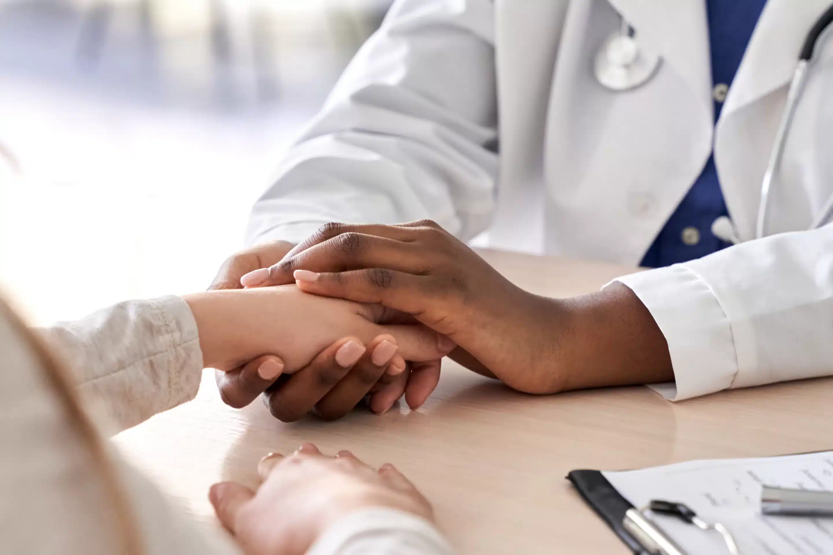 African female doctor hold hand of caucasian woman patient give comfort