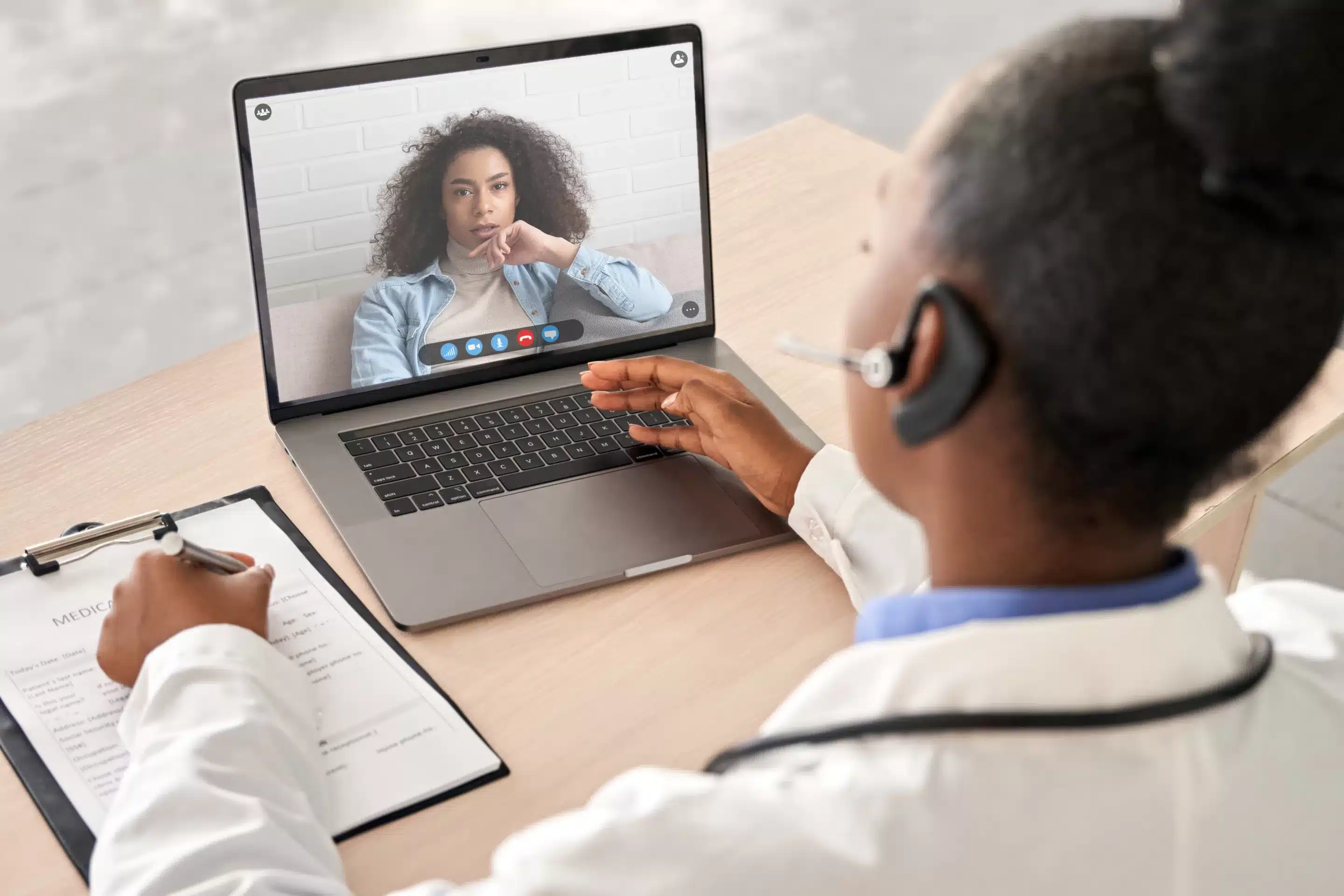 person sitting while using laptop computer and green stethoscope near