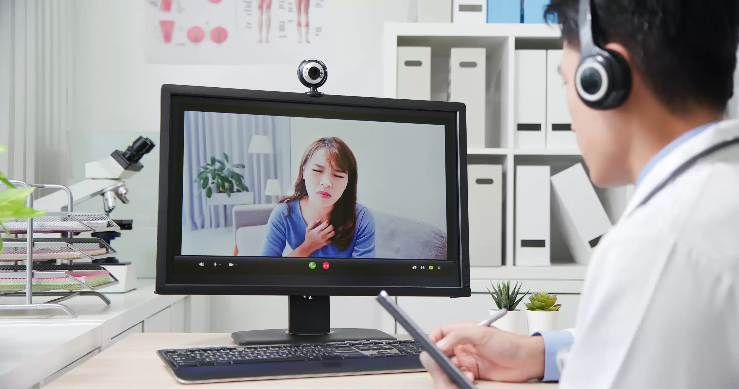 person sitting while using laptop computer and green stethoscope near