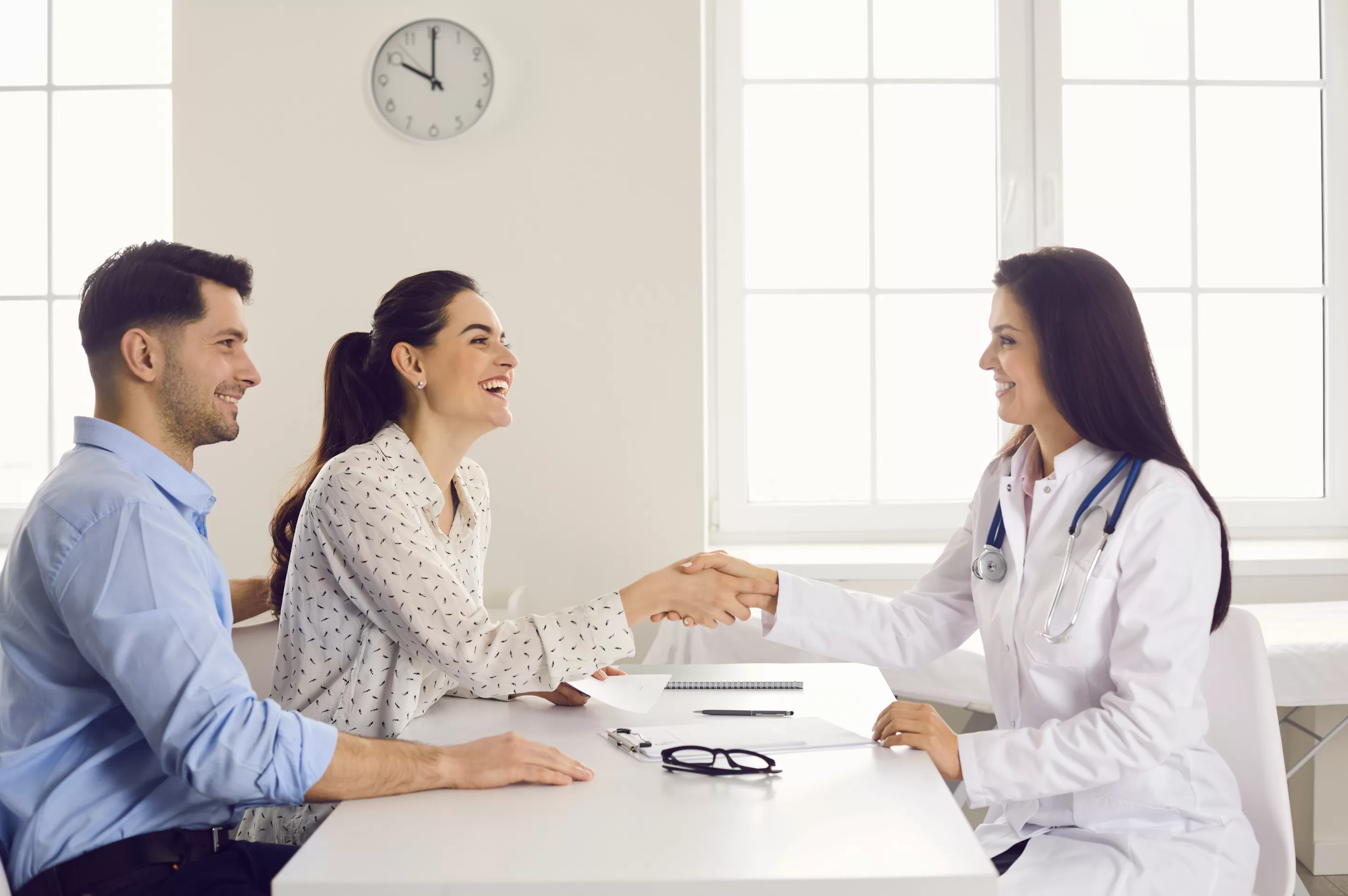 Happy woman patient giving gratitude handshake to doctor get good