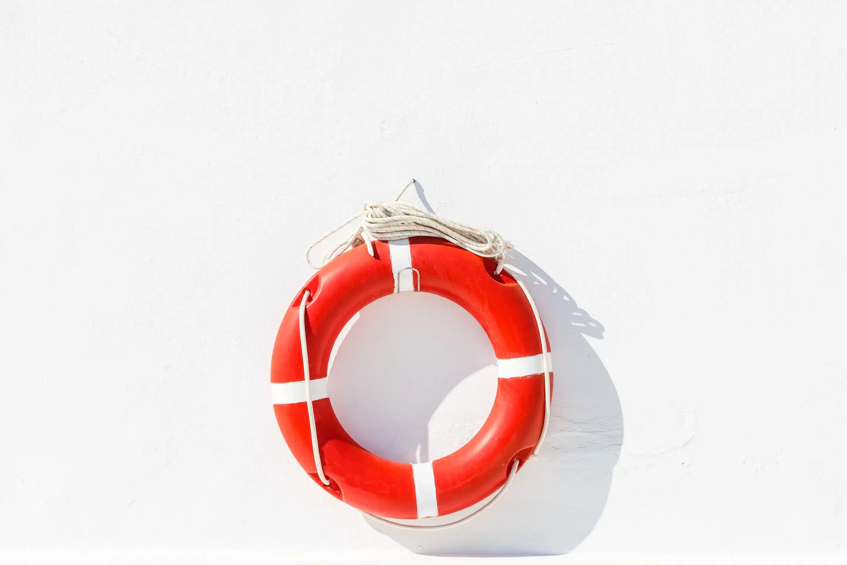 Orange lifesaver buoy hanging on a white wall