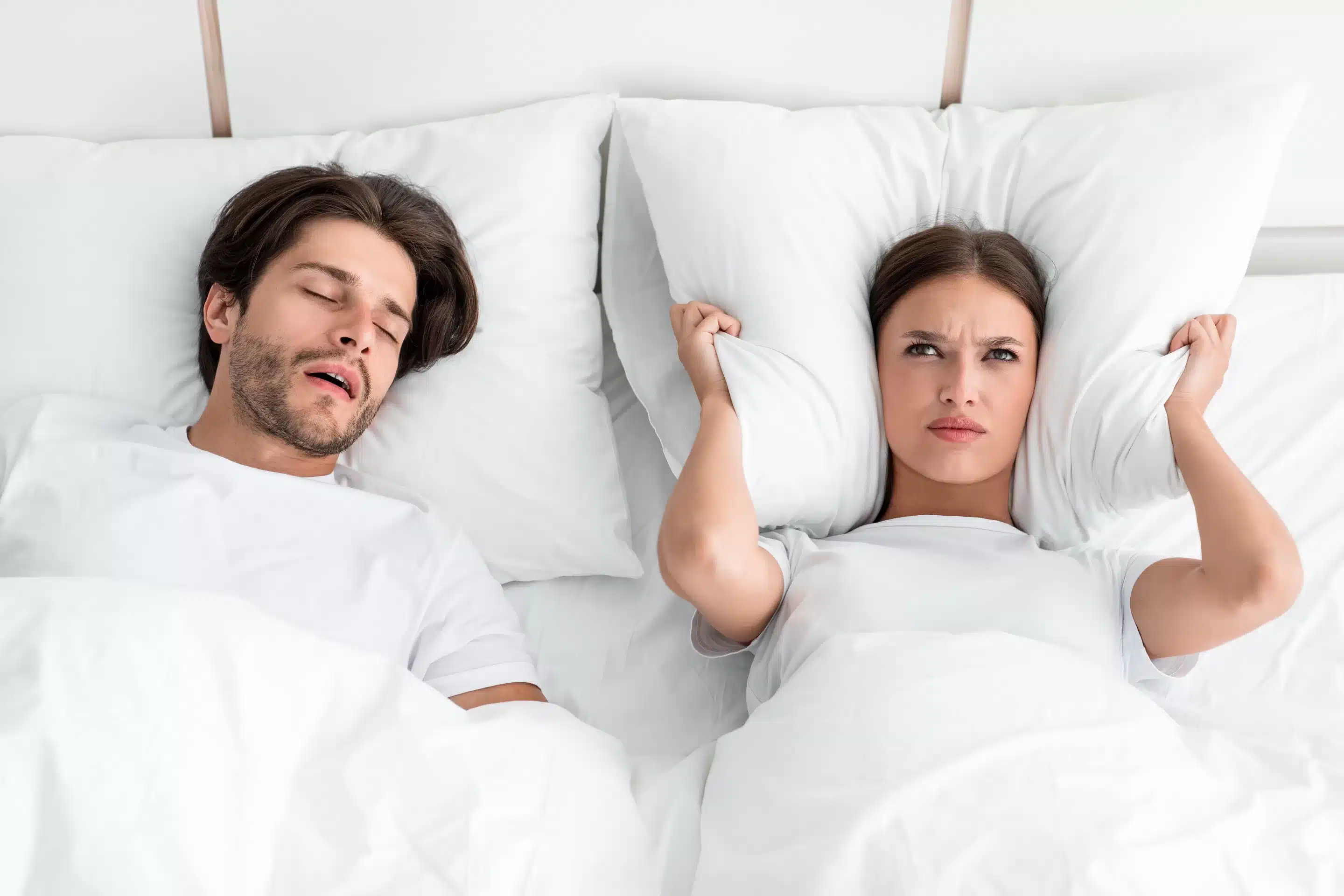 Attractive millennial european guy with stubble sleeps on bed