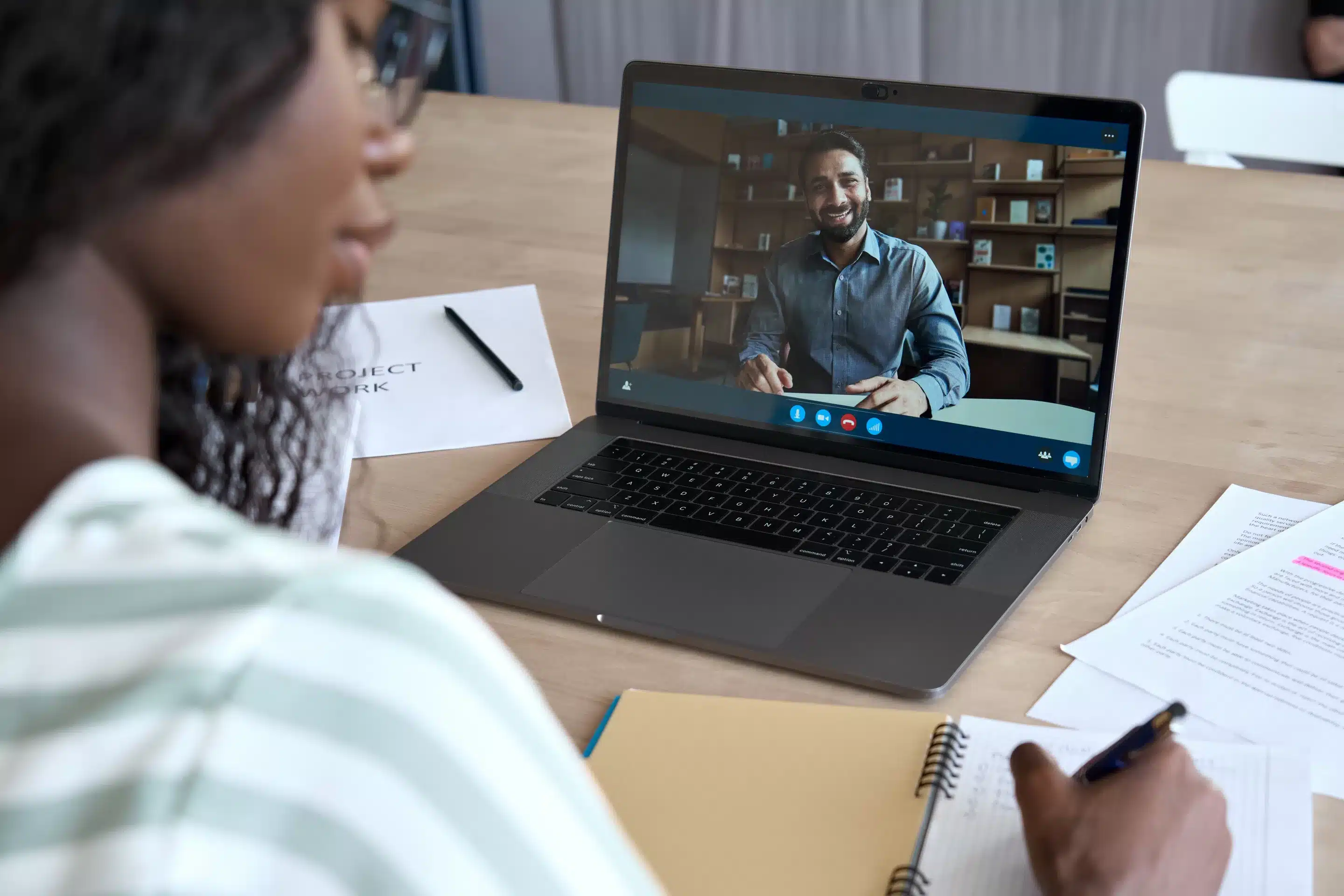 a woman talking to a man on a laptop