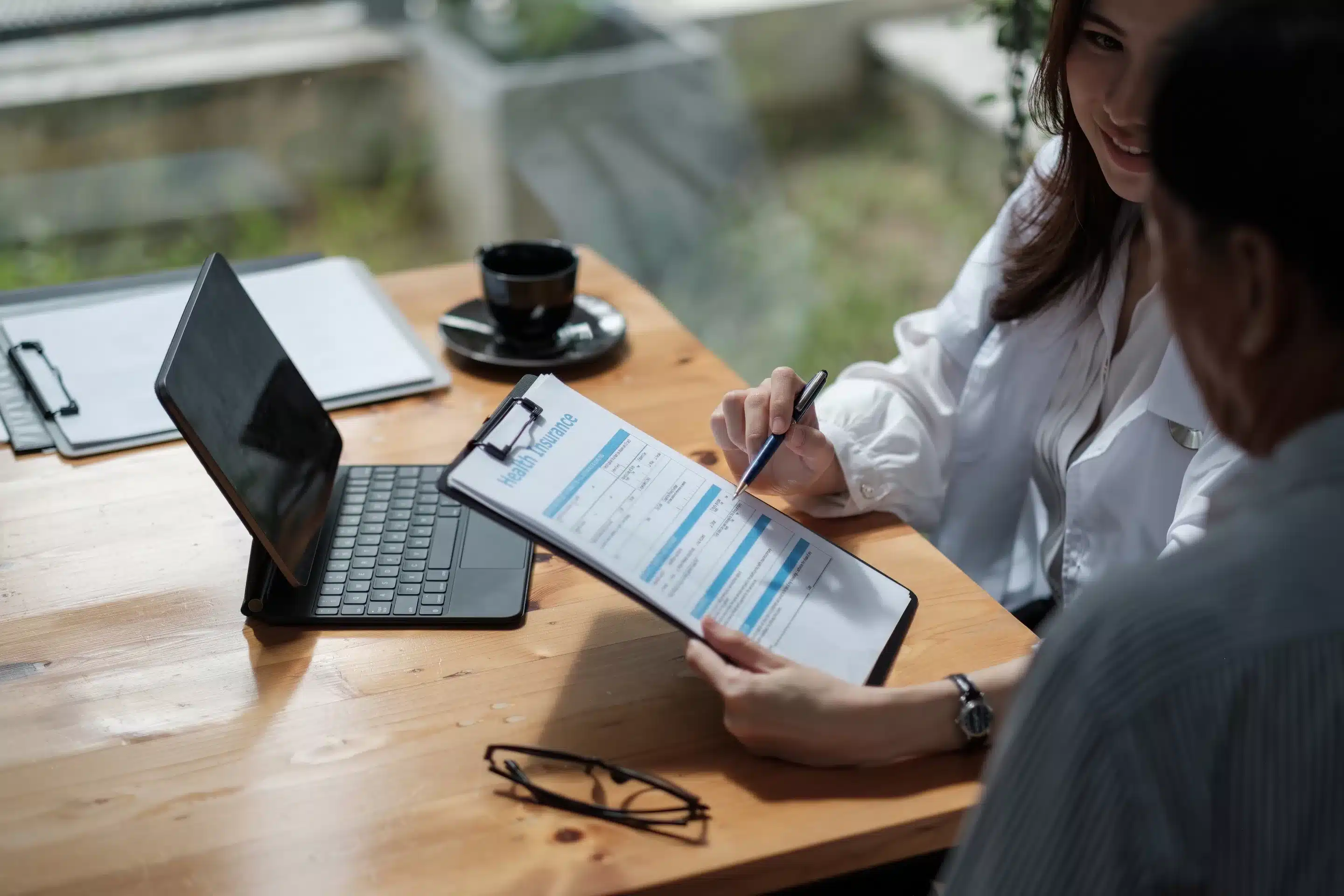 Female health insurance broker presenting his insurance benefits to businessman