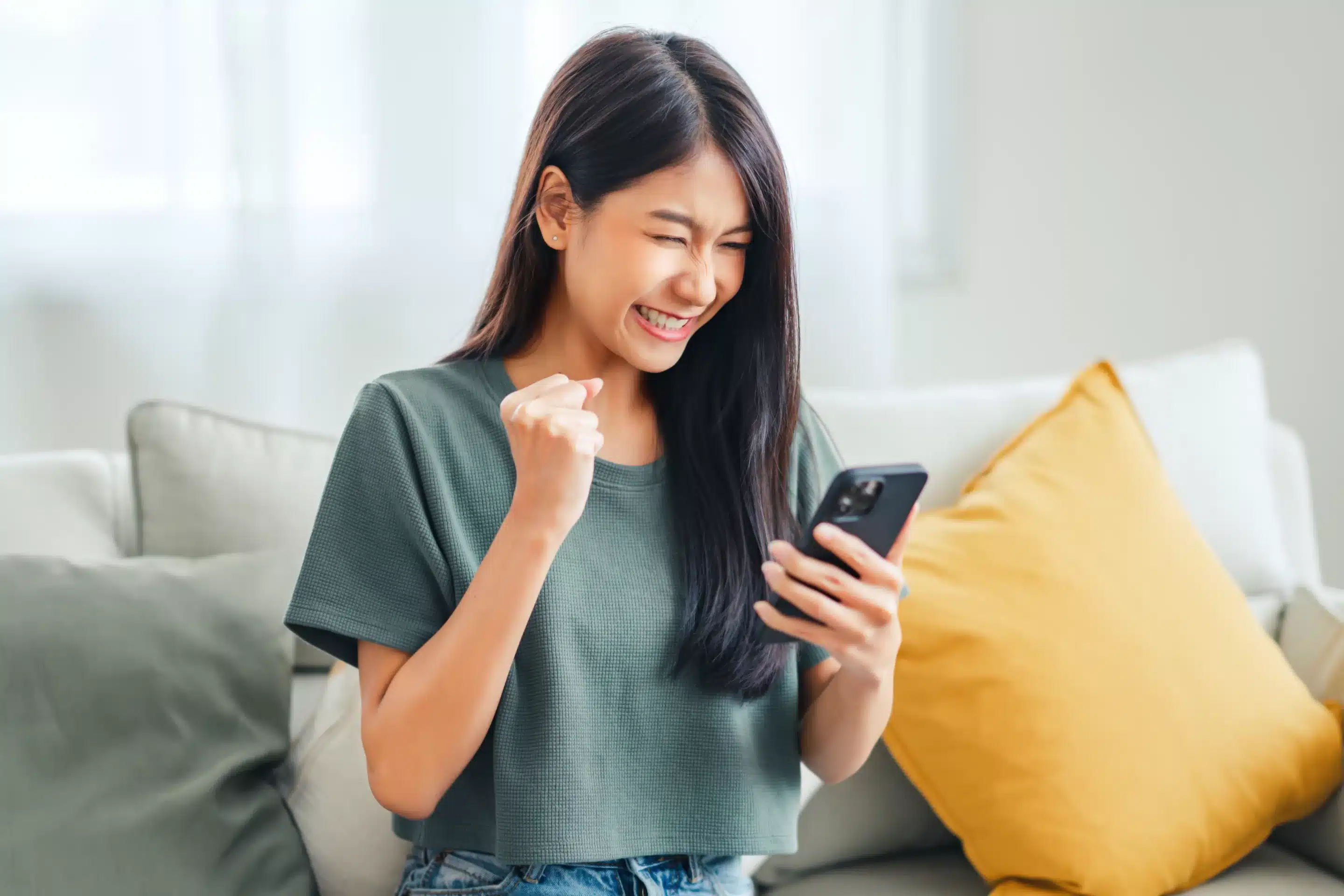 Excited young asian woman hold phone chatting in dating app feel happy