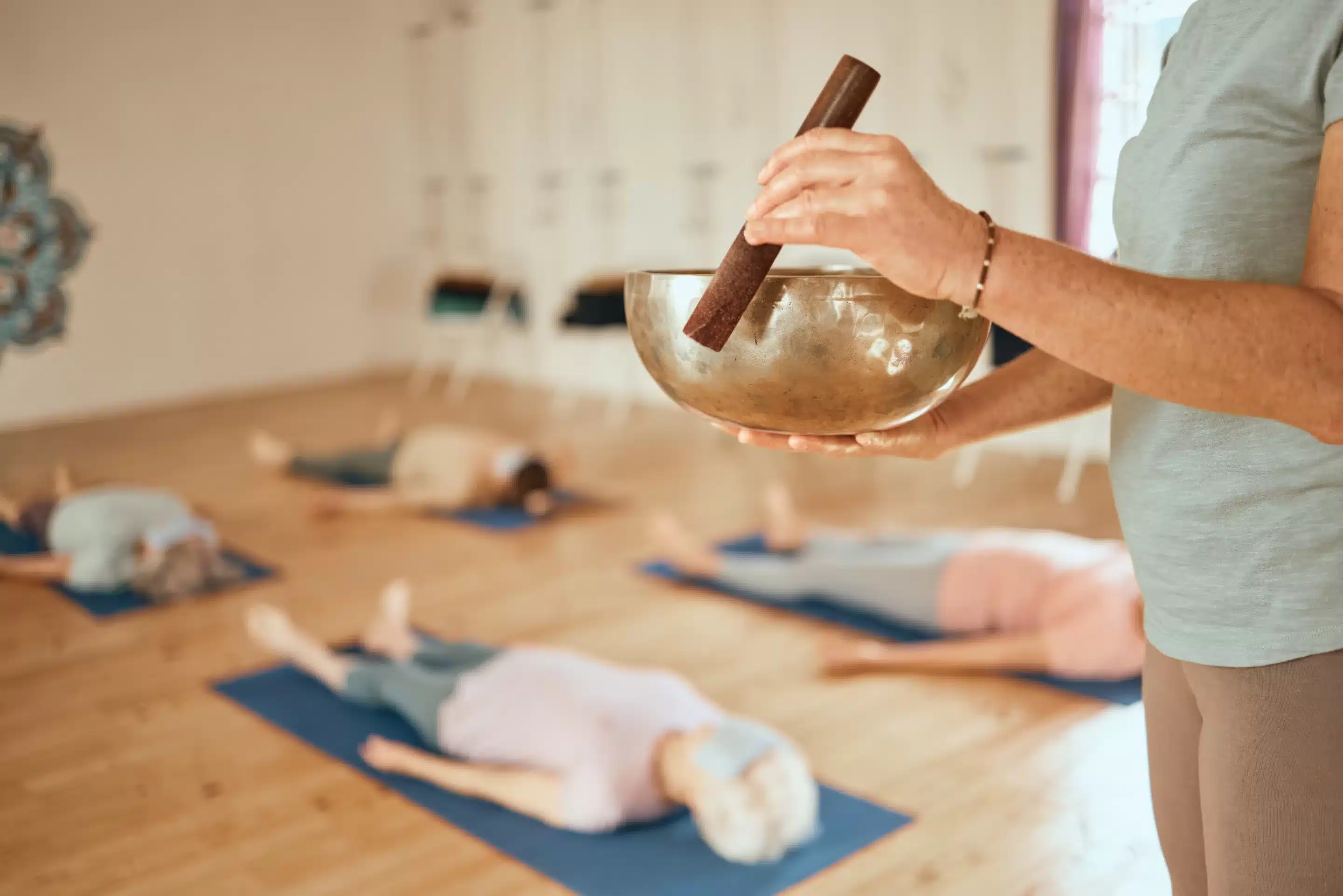 Yoga, class and woman with Tibetan singing bowl for meditation, calm and mindfulness in yoga class