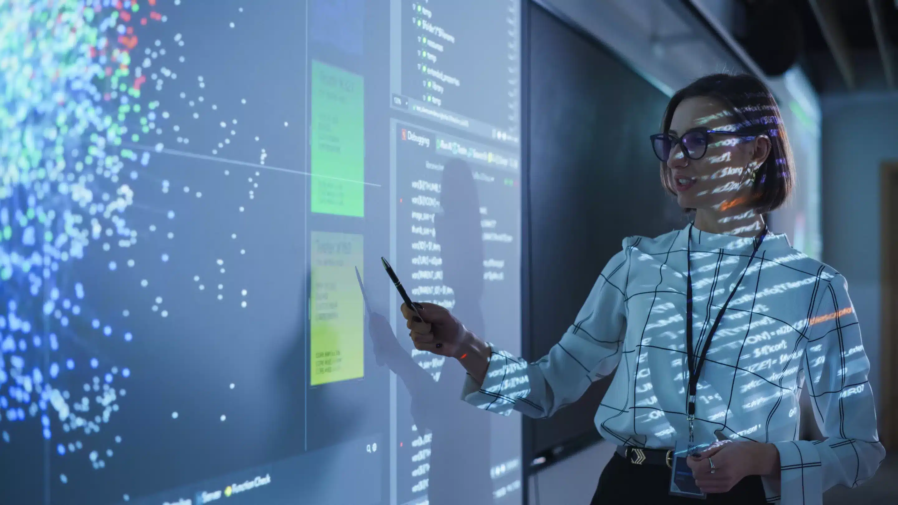 Young Female Teacher Giving a Data Science Presentation in a Dark Auditorium