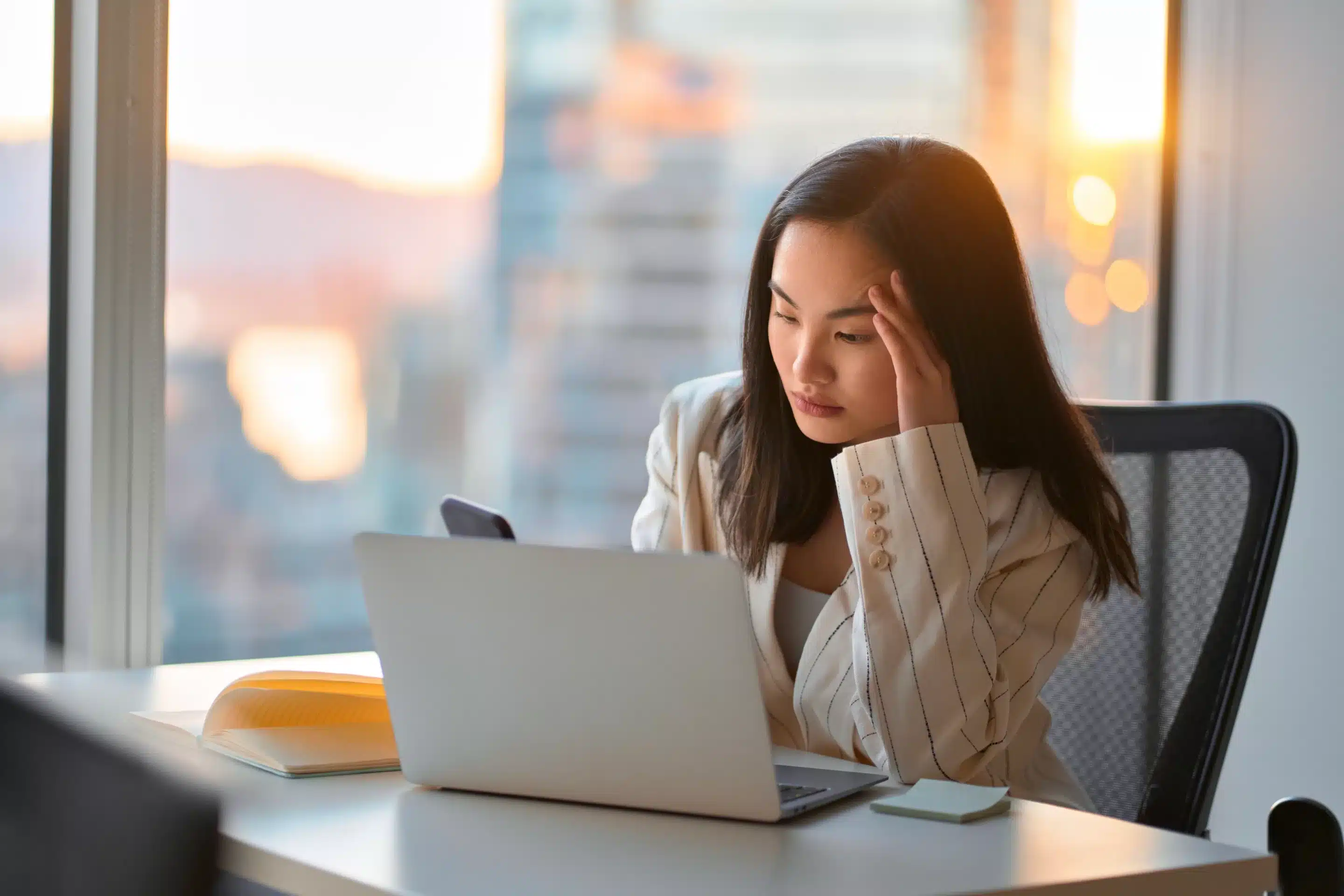 Young busy stressed upset Asian business woman holding cellphone