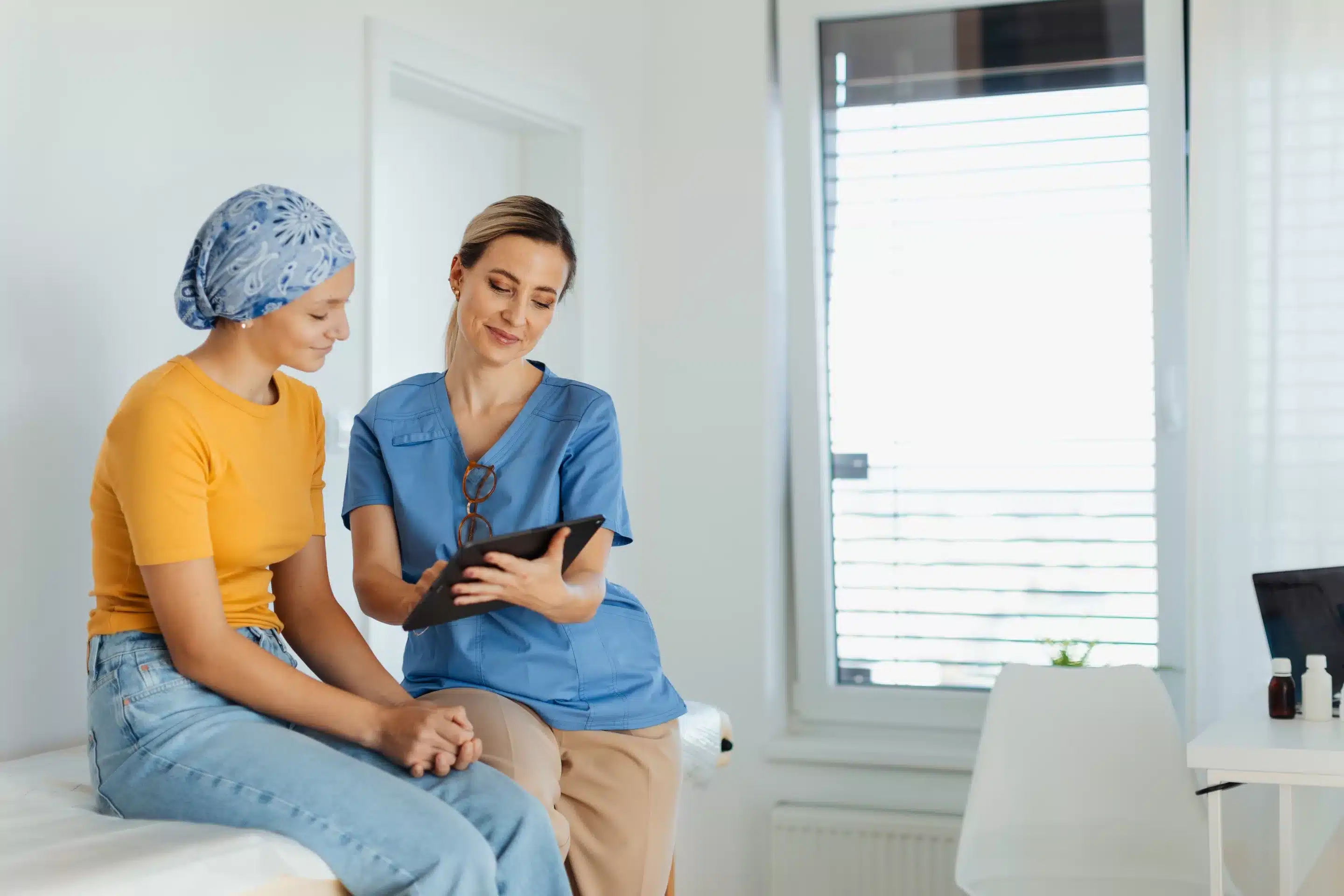 Teenage oncology patient talking with doctor