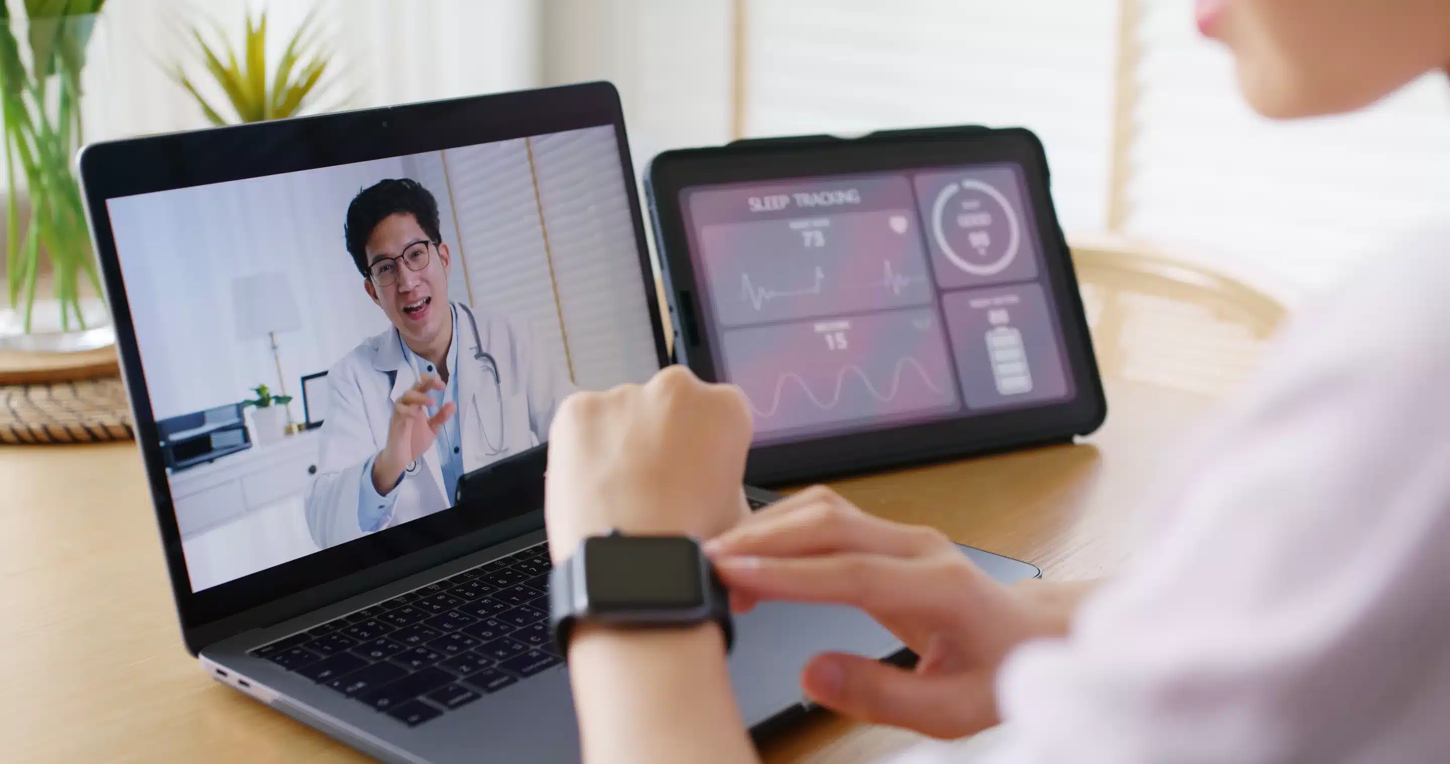 person sitting while using laptop computer and green stethoscope near