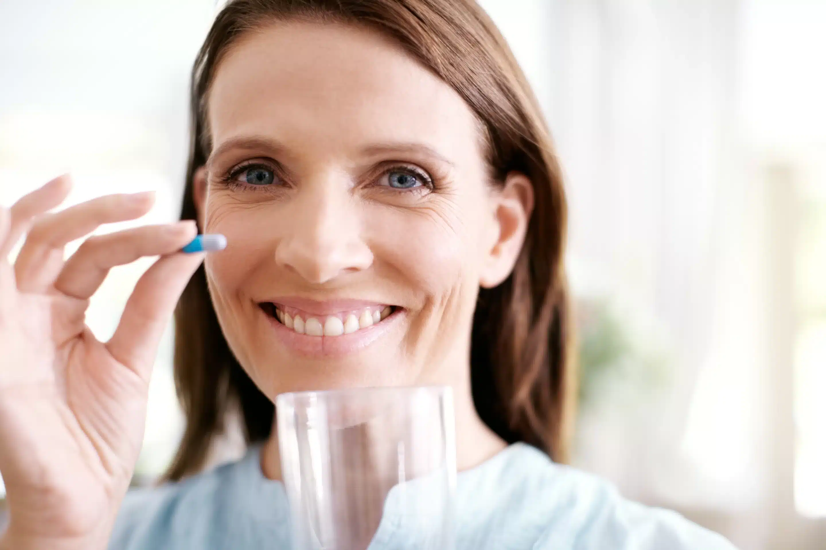 Woman, portrait and vitamin capsule for health in home