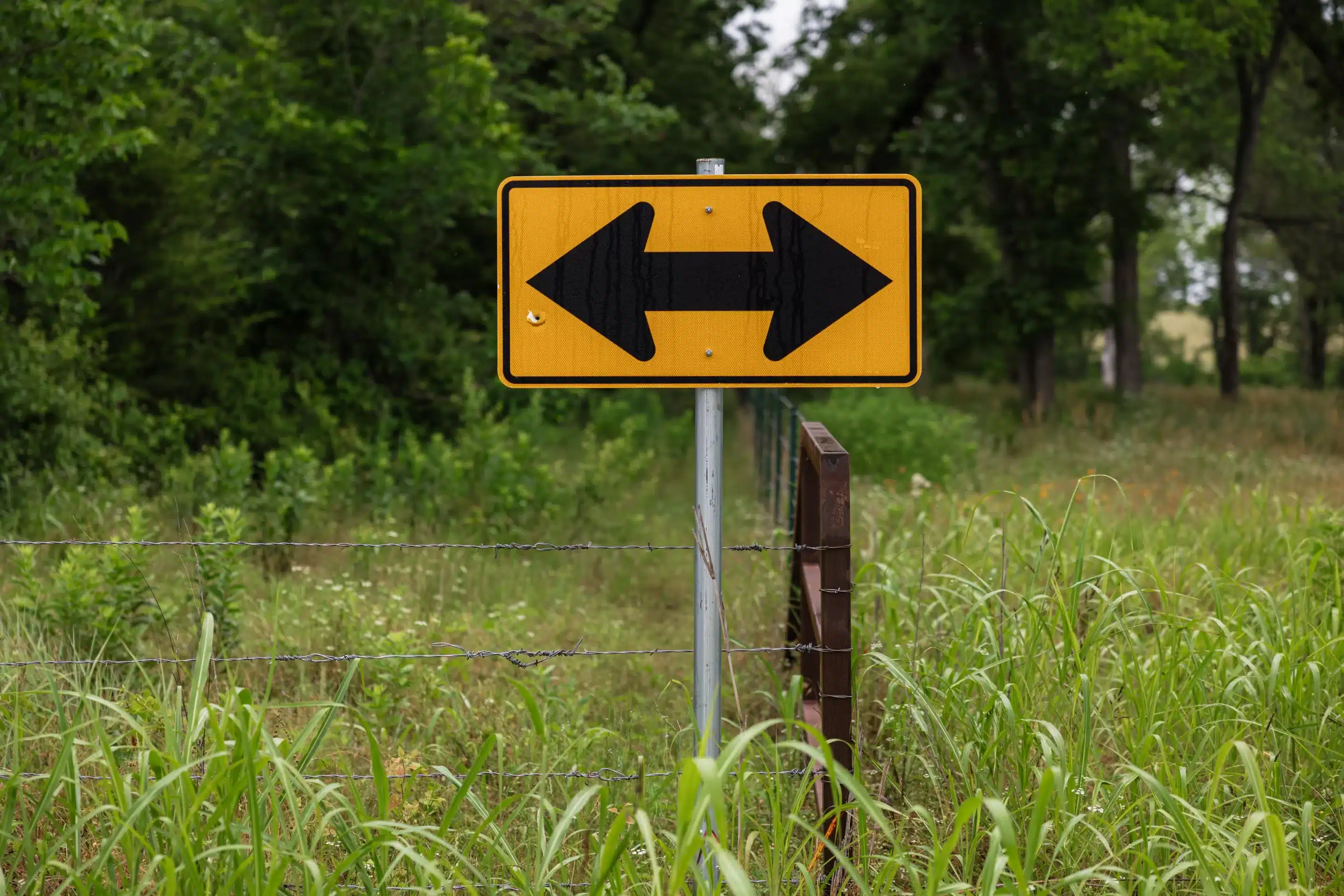 Yellow road sign with a double-sided arrow