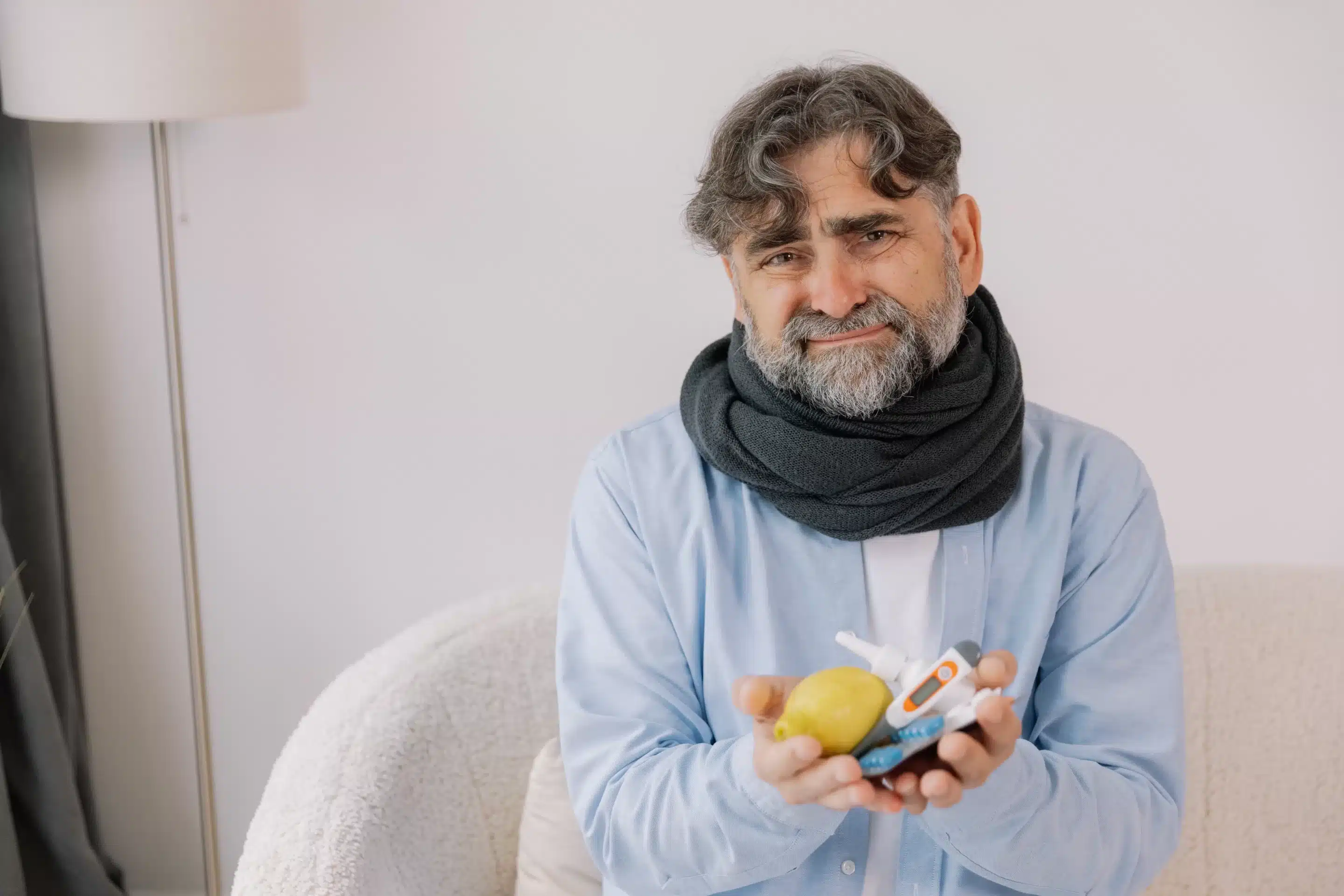 Senior gray bearded excited man in scarf having acute viral infection