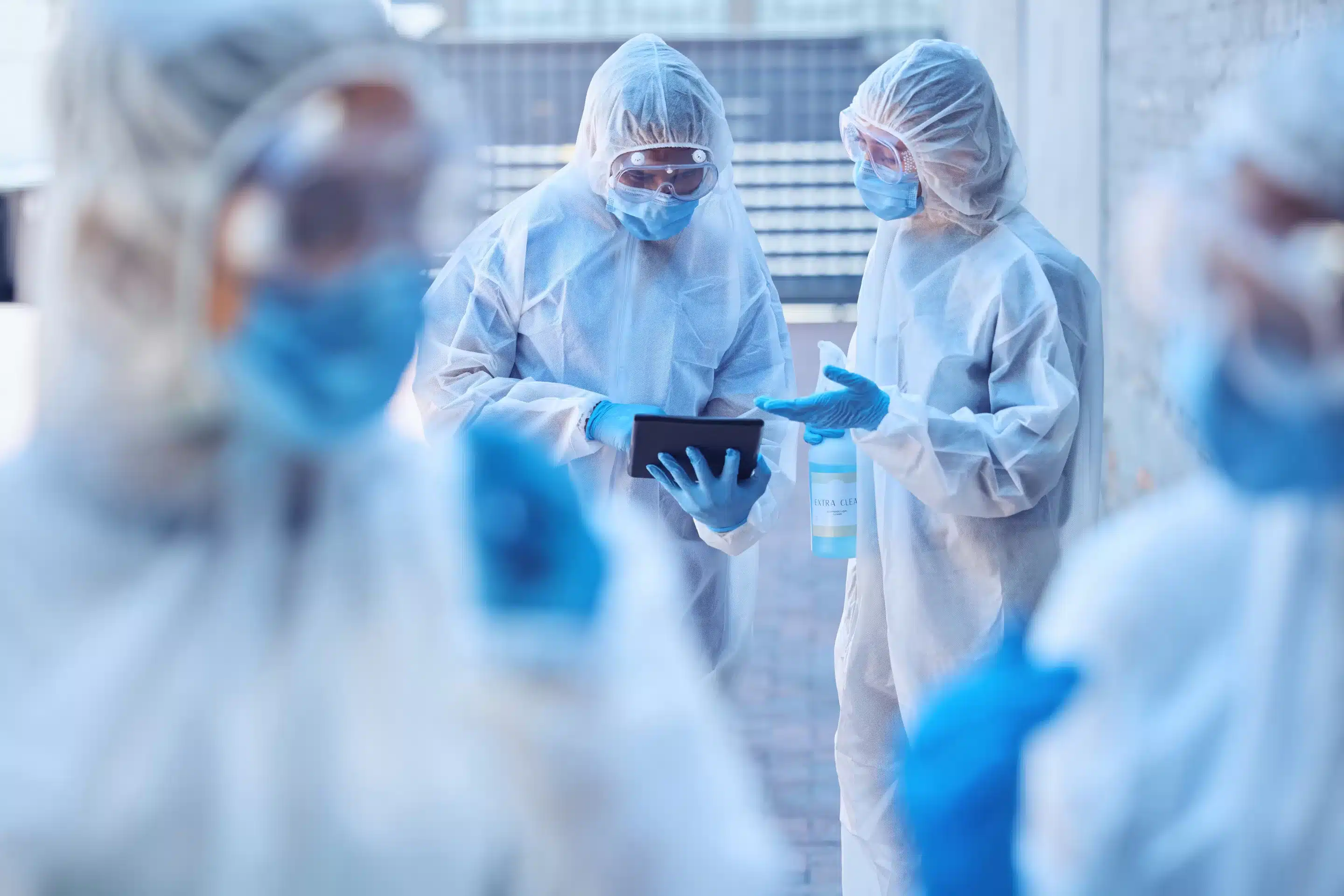 a group of people wearing white hazmat suits and face masks