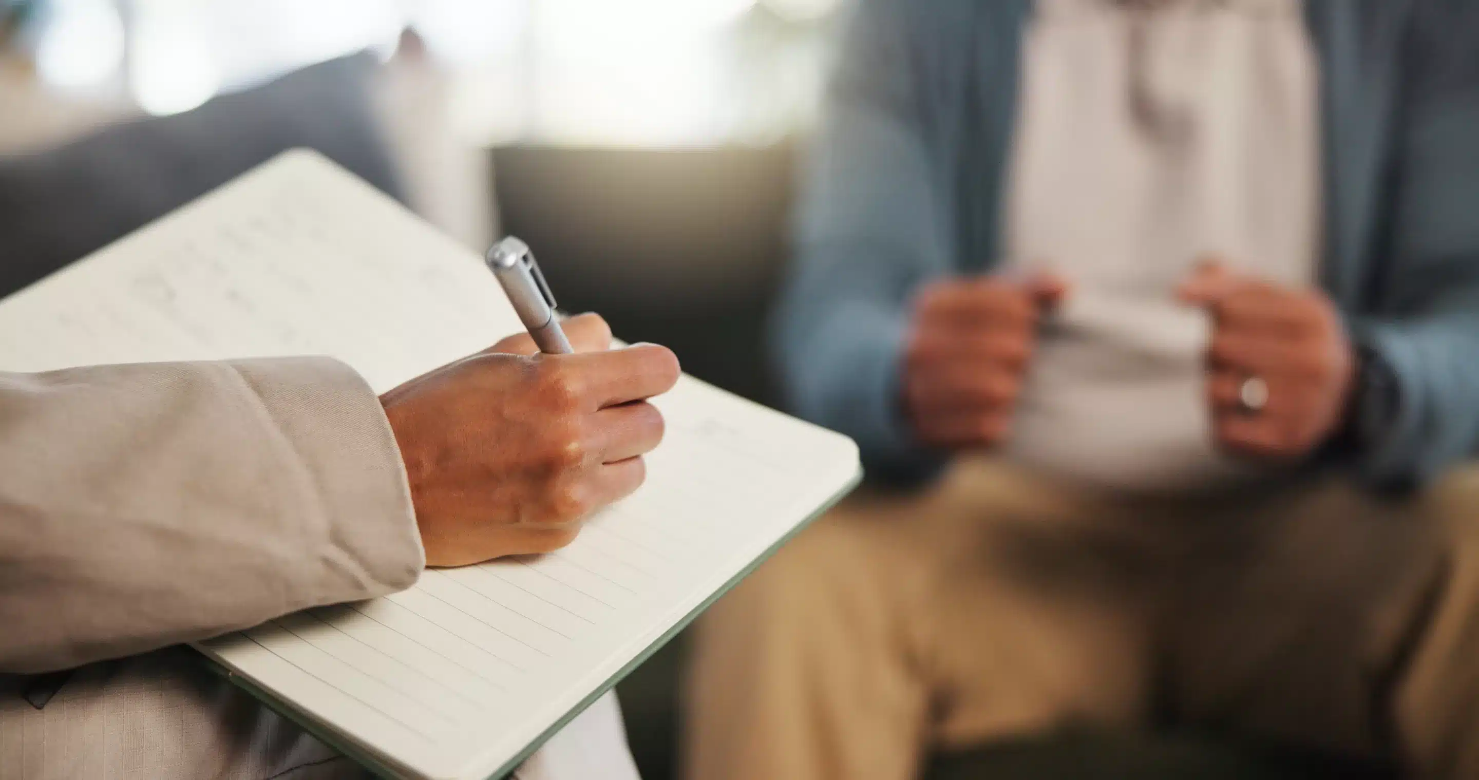 a person holding a pen in a notebook