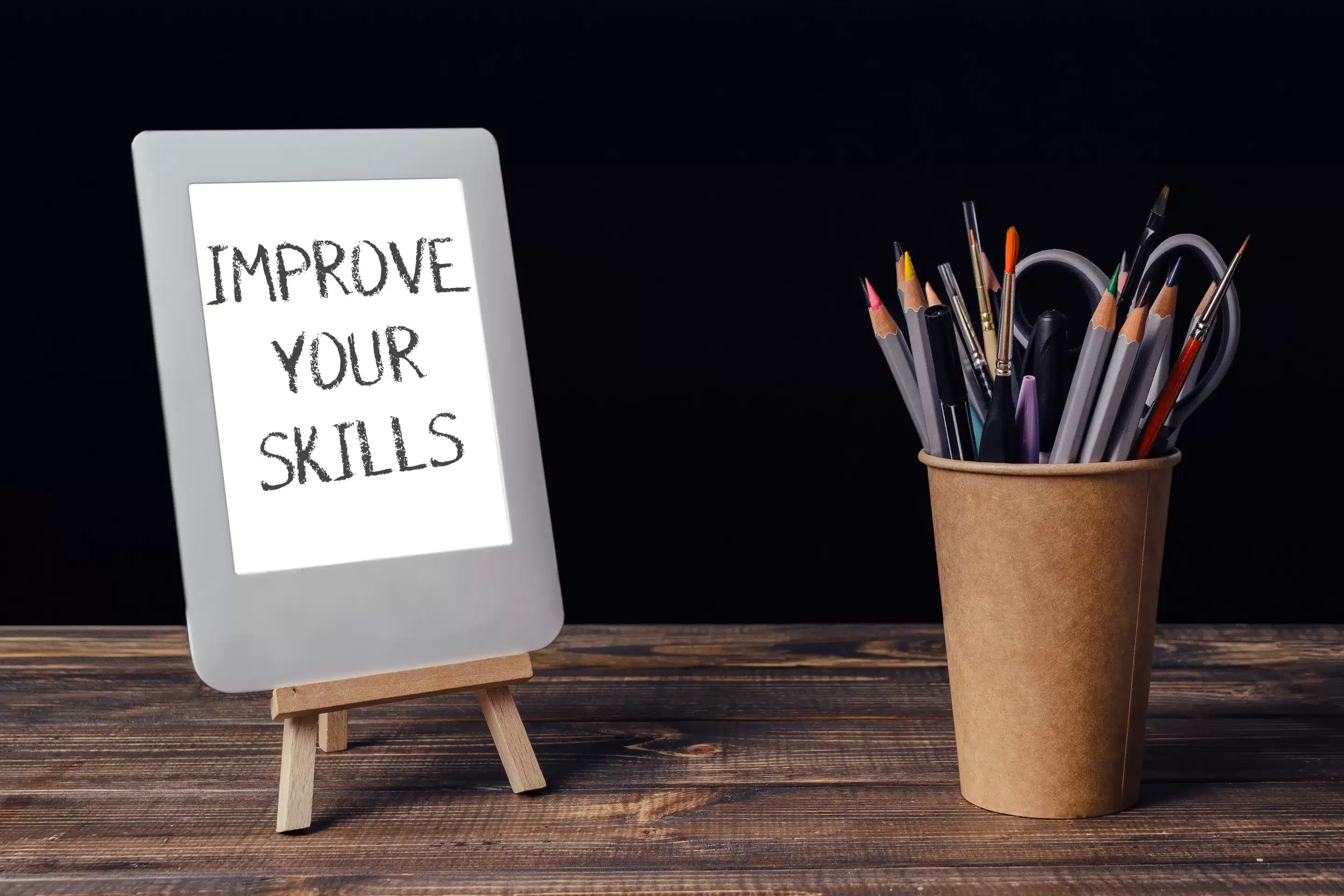 A white tablet with the words improve your skills written on it.