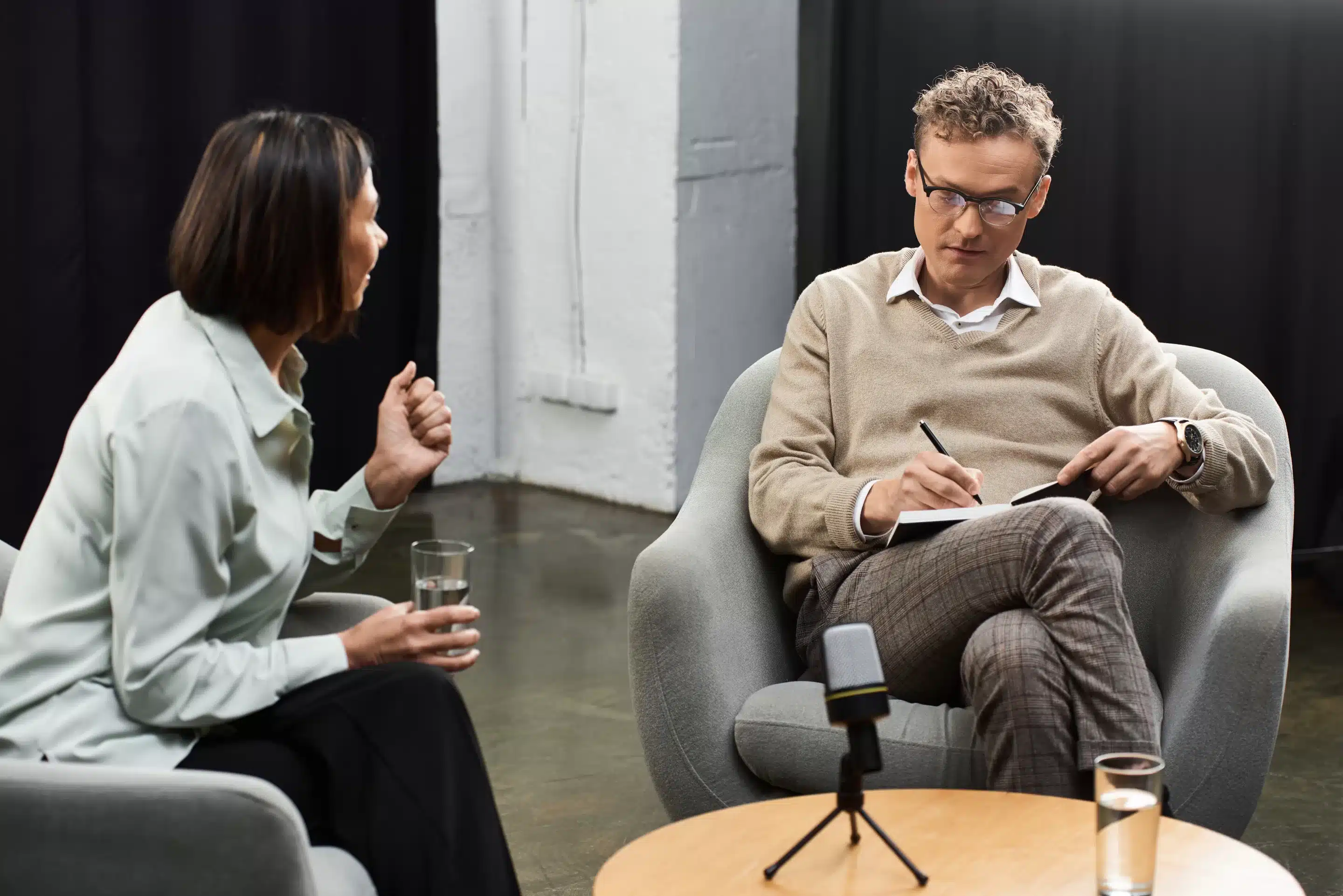 a man and woman sitting in a chair talking
