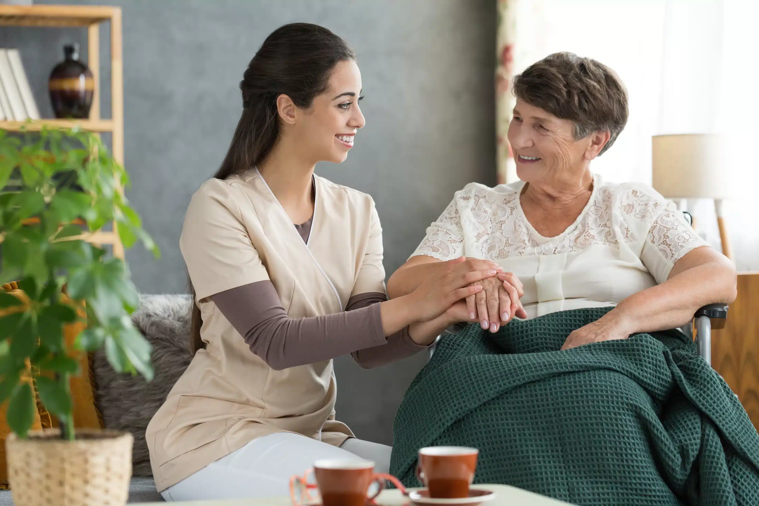 a woman holding a hand of an old woman
