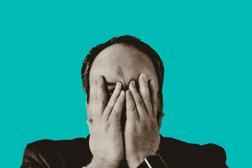 Man covering his face in disappointment