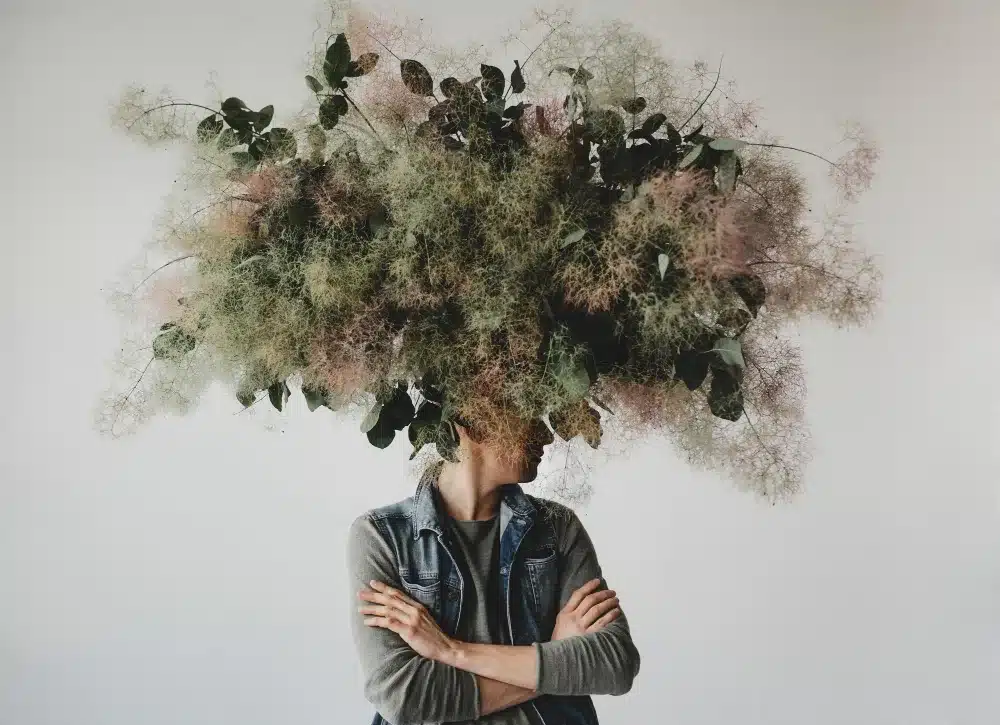 <br />
Large decorative bouquet made of green leaves and moss hangs over man's head