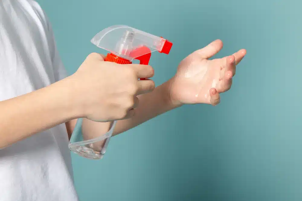 Close-up of a young boy using a spray bottle, focused on spraying
