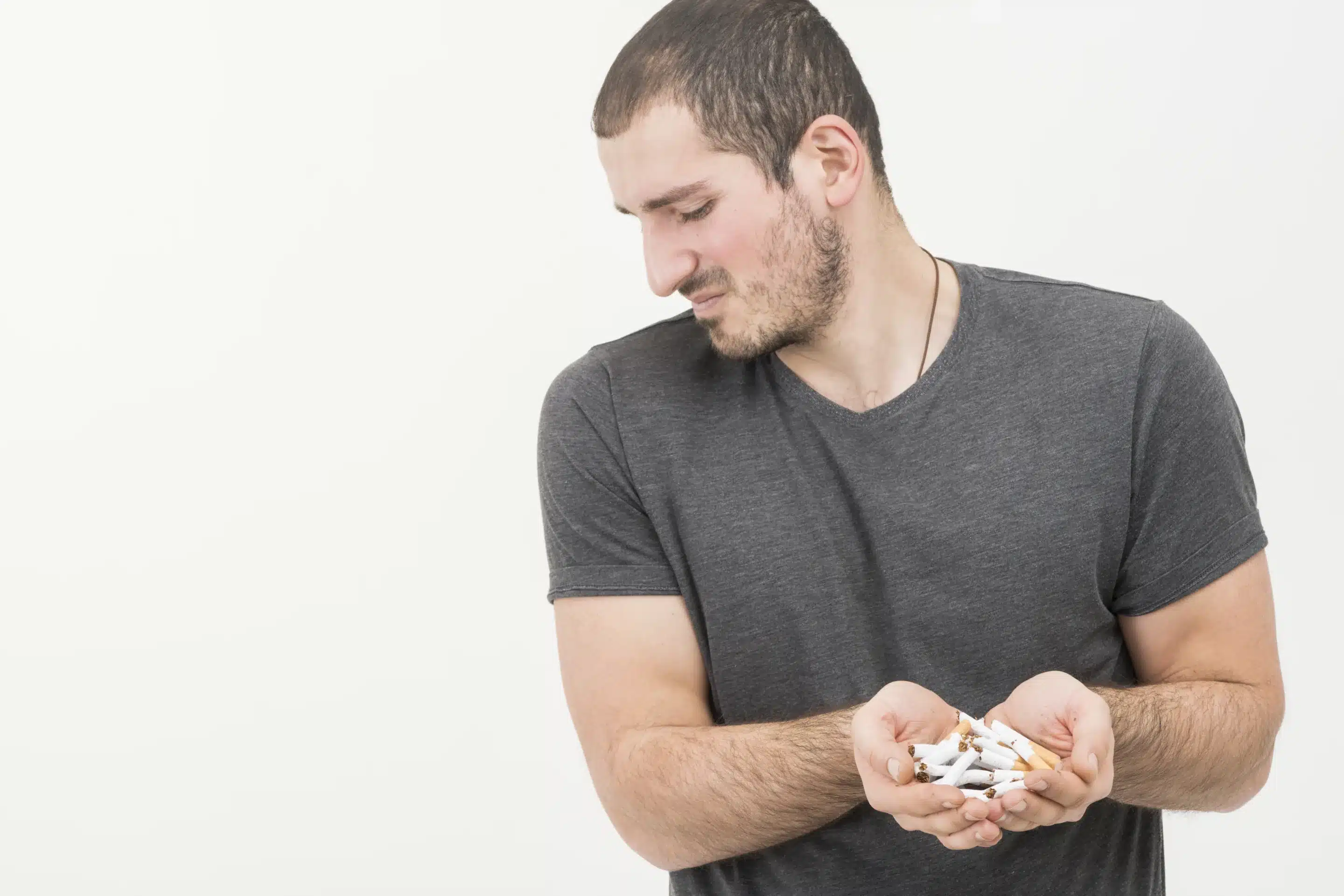young man holding broken cigarettes in hand
