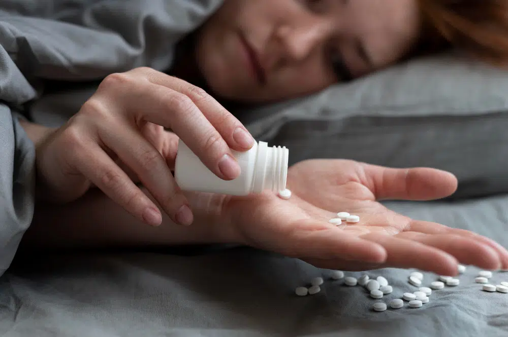 Close-up of depressed woman holding medication with troubled expression