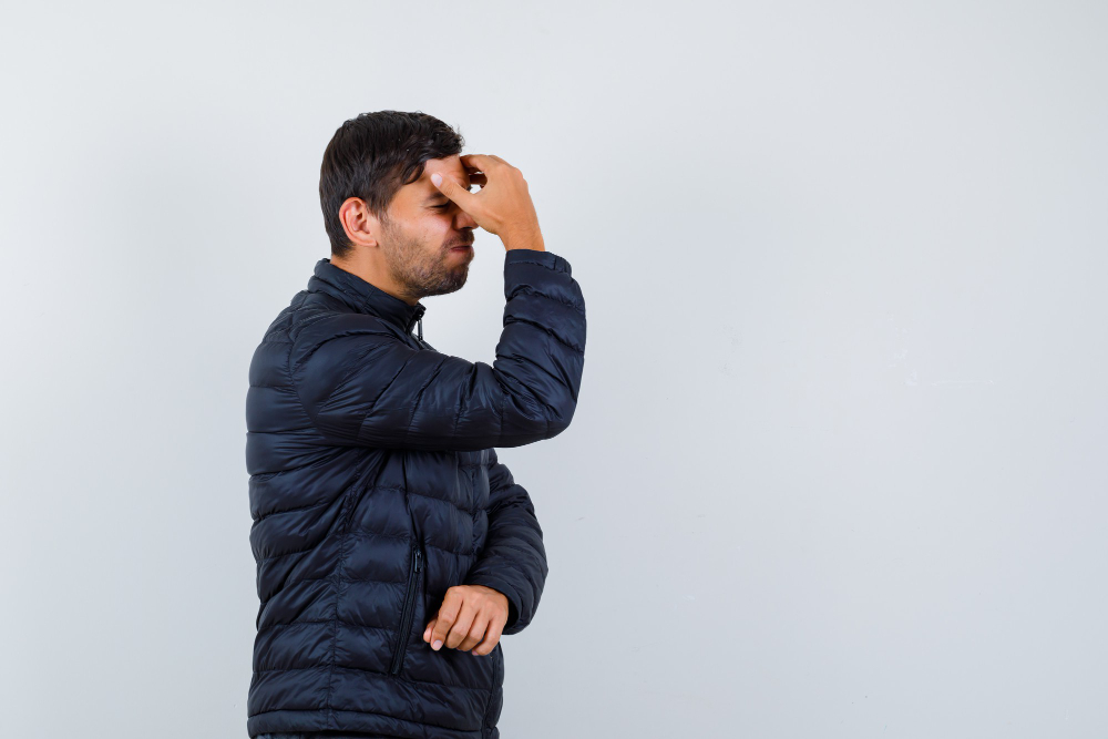 Expressive young man striking a pose in a studio setting with a neutral background